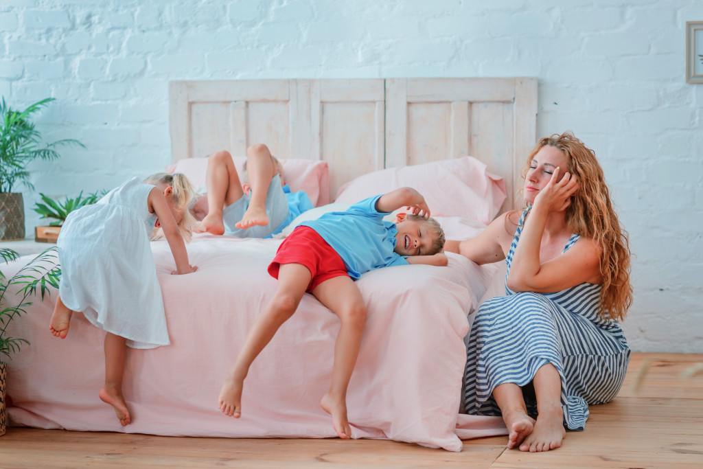 children with their mom on their bed
